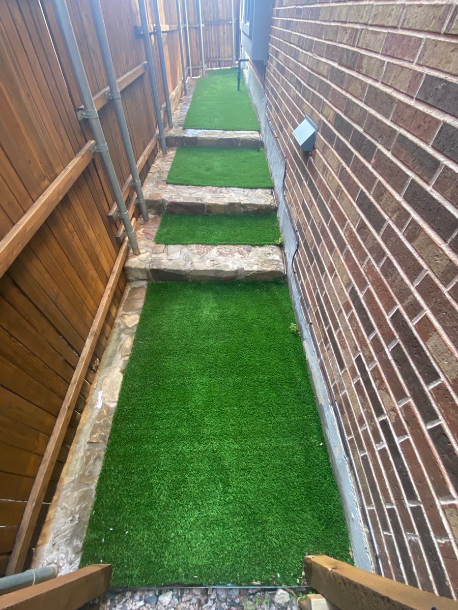 Finished 500-square-foot residential artificial turf side yard after professional cleaning in Lewisville, Texas