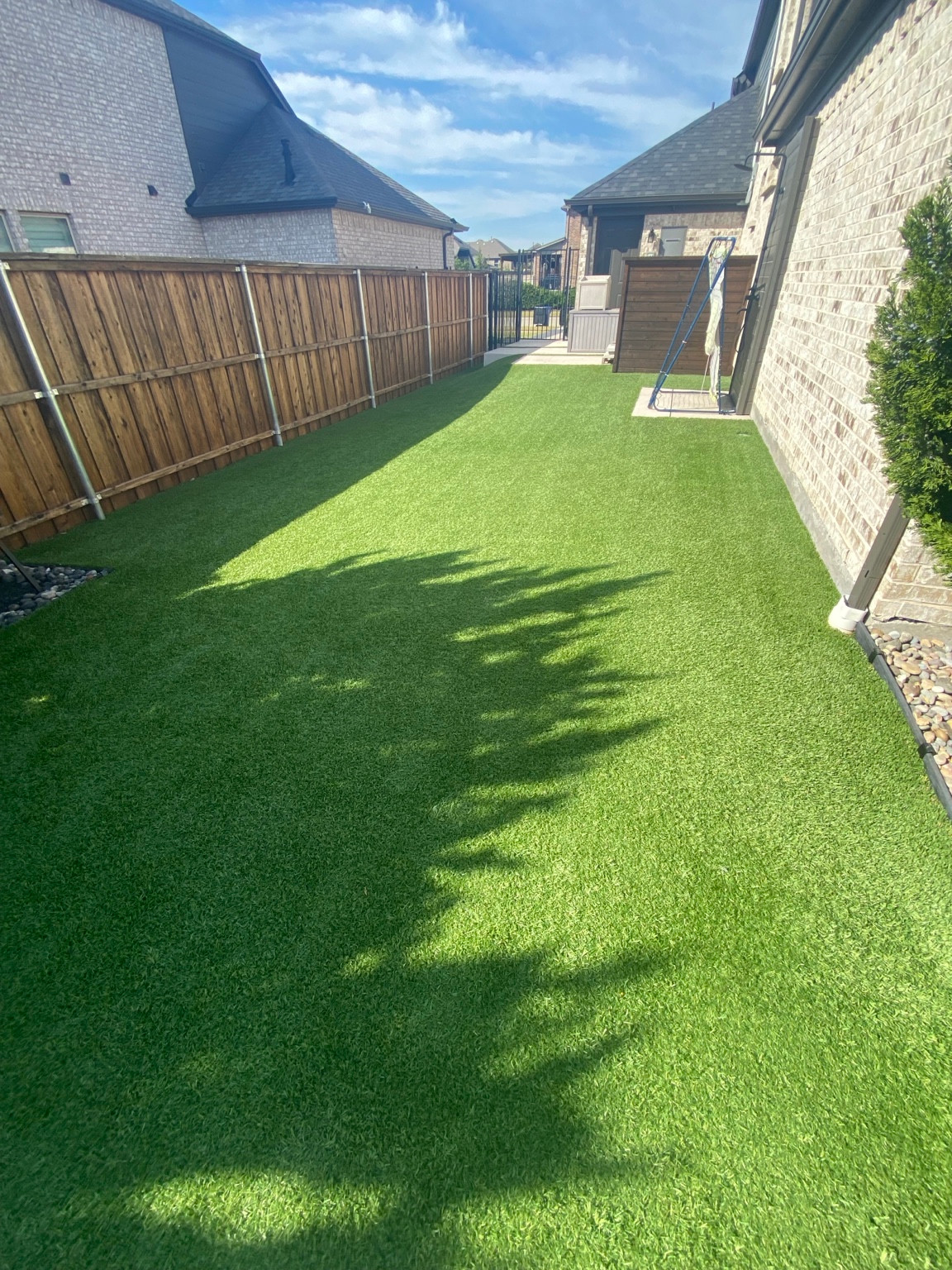 Finished side-yard view after a 900-square-foot residential artificial turf cleaning in Frisco, Texas