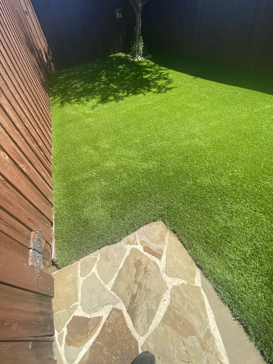 Cleaned and groomed artificial turf in a fenced residential backyard