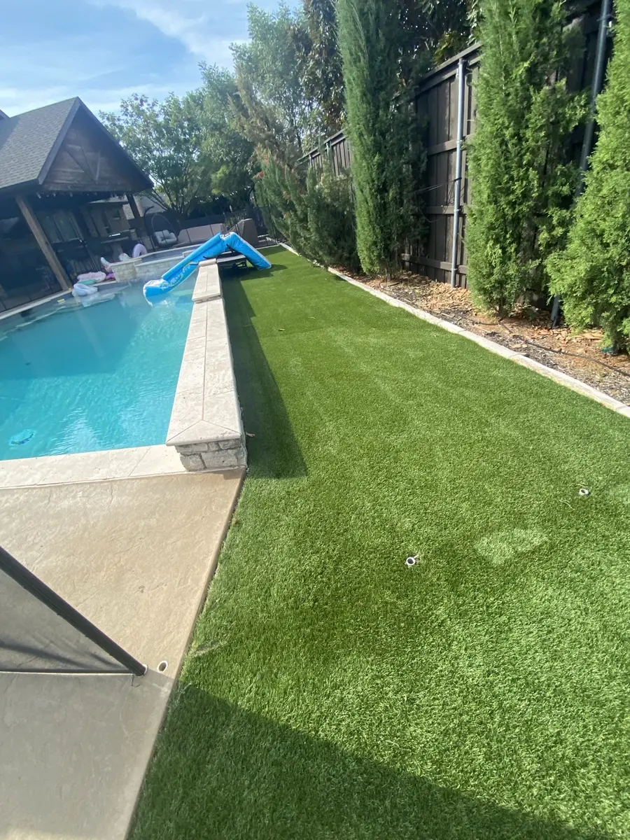 Artificial turf after cleaning beside a swimming pool